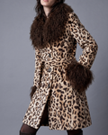 Leopard print mid length penny lane coat with dark brown shaggy curly Mongolian fur collar and cuffs shown on model walking against grey background .